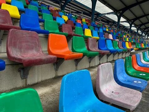 Side view of rows of plastic seats of different colors forming bleachers Stock Photos