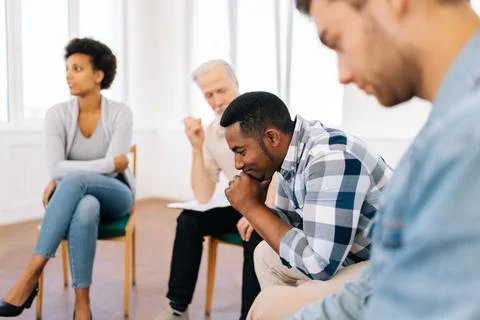 Side view of sad pensive young African American man talking about mental state Stock Photos