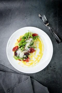 Side view of salad with red fish, herbs and cheese on a white plate Stock Photos