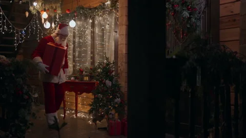 Side view Santa Claus carries and delivers a gift in his hands in winter on the Stock Footage 166160741