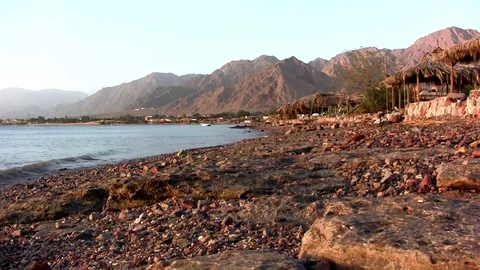 Side view of sea waves low angle with a few boats and Sinai mountains Red Sea Stock Footage 71933074
