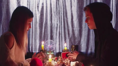 Side view of seer man uses taro cards to predicting future to his female client Video stock 143514109