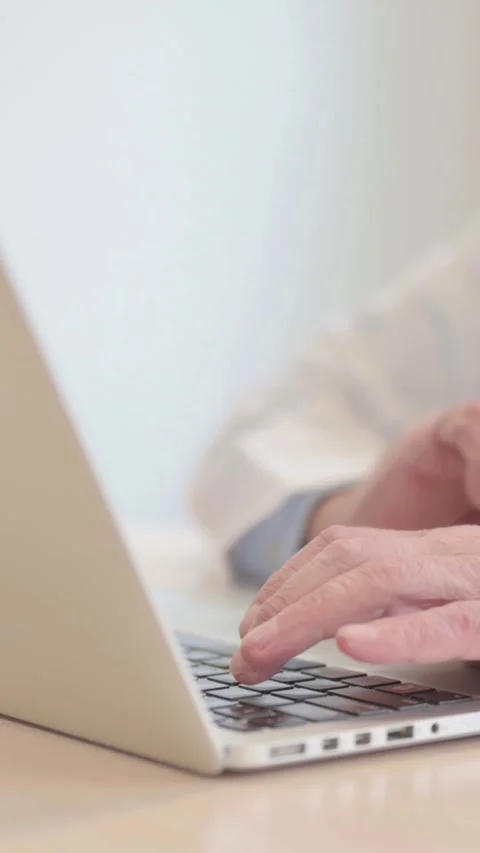 Side View of Senior Doctor Typing on Laptop, vertical video Stock Footage 328974895