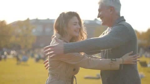 Side view of senior man and adult daughter meeting in park and hugging Video stock 141181979