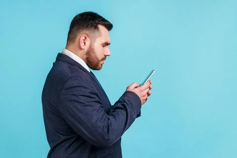 Side view serious assertive man wearing official style suit using online Stock Photos