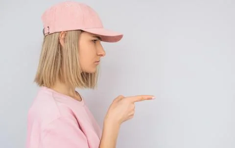 Side view of serious casually dressed in pink with cap Caucasian blonde femal Stock Photos