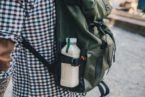 Side view shot. Close up man walking with plastic bottle of detox nutrition milk Stock Photos