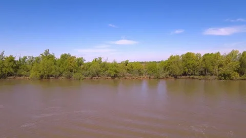 Side view shot from moving vessel navigating muddy brown waters Stock Footage 346263036