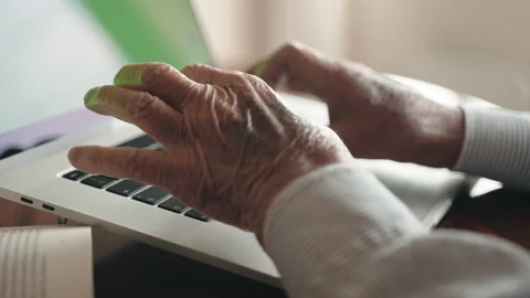 Side view shot of old wrinkled man's hands typing on computer keyboard Stock Footage 168256754