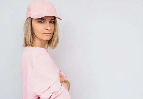 Side view shot of serious casually dressed in pink with cap Caucasian blonde  Stock Photos