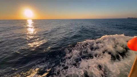 Side view from the side of a ship towards a rising or setting sun at sea Stock Footage 315289706