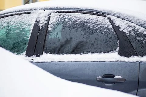 Side view of a silver car covered in snow after a storm Stock Photos