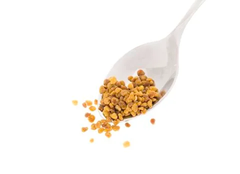 Side view of silver spoon with bee pollen, white background Stock Photos