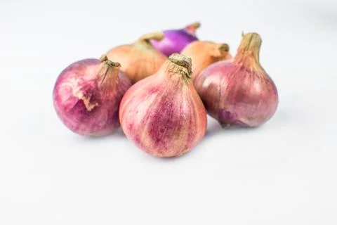 Side view of six medium size fresh and ripe red onion isolated on a white bac Stock Photos