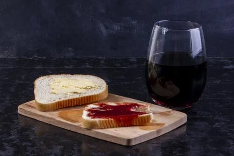 Side view a slice of bread and butter with a slice of bread with jam on a b.. Stock Photos