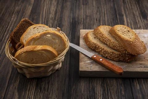 Side view of sliced breads brown seeded cob with knife on cutting board and.. Foto stock