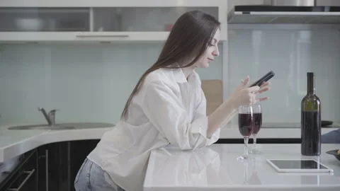 Side view of slim beautiful millennial woman surfing Internet on smartphone with Video stock 144612023