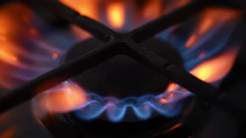 Side view slow-motion of a black gas stove igniting with dancing blue-red 動画素材 318850886