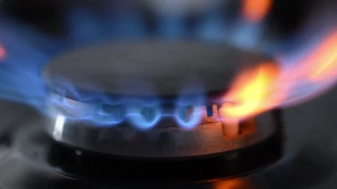 Side view slow-motion of a black gas stove igniting with dancing blue-red 動画素材 318850896