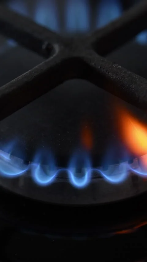 Side view slow-motion of a black gas stove igniting with dancing blue-red 動画素材 319493898
