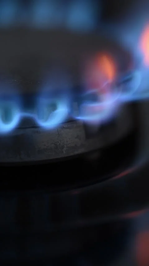 Side view slow-motion of a black gas stove igniting with dancing blue-red 動画素材 319493929