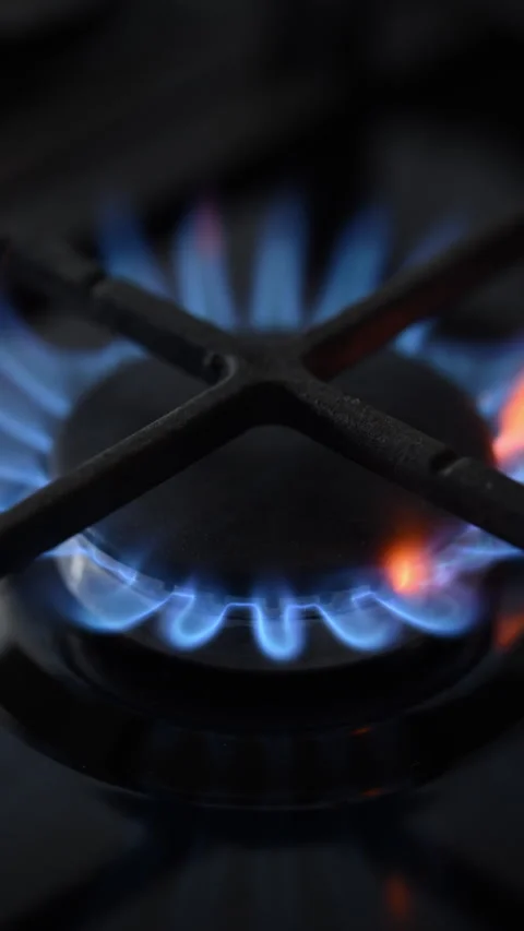 Side view slow-motion of a black gas stove igniting with dancing blue-red 動画素材 319494060