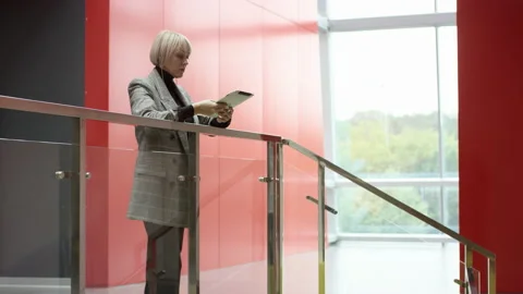 A side view slow motion close up shot of a blonde business woman standing inside Stock Footage 133466056