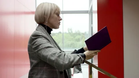 A side view slow motion close up of a blonde female executive having a look at Stock Footage 137820768