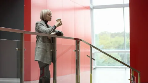A side view slow motion close up of a blonde business woman drinking her coffee Stock Footage 139713331