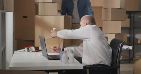 Side view of small business owners working together in a warehouse. An old man Stock Footage 149476496