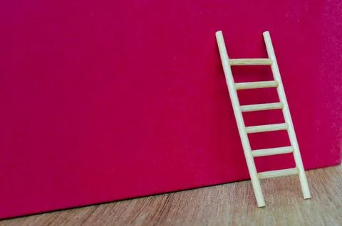 Side view of small ladder on dark red cover background with customizable sp.. Stock Photos