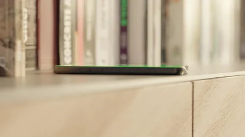 Side view of a Smartphone with a Green Screen on the table with books Stock Footage 253636783