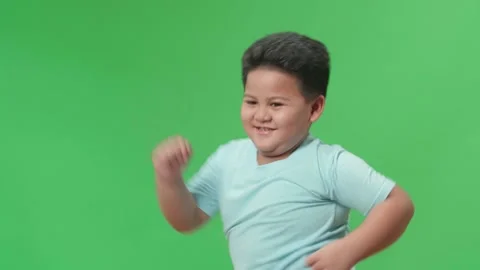 Side View Of Smiling Asian Little Boy Dancing In A Green Screen Studio Stock Footage 163280948