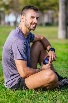 Side view smiling Man Resting on Grass After Workout.Vertical Stock Photos