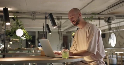 Side view of smiling man typing on laptop at cafe Vídeo Stock 159083853