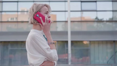 Side view smiling middle-aged Caucasian blonde woman talking mobile phone while Stock Footage 247959519