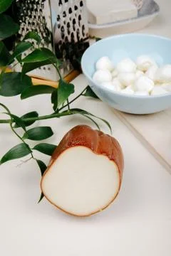 Side view of smoked cheese on a table with grater and a bowl filled with mini Stock Photos