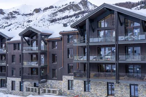 Side view of snowy construction site with new appartment building on the alpine Stock Photos