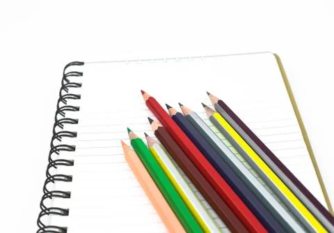 Side view of some various colored pencil crayons scattered on top of an open Stock Photos