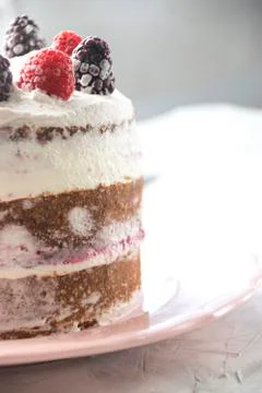 Side view of a sponge cake filled with whipped cream and berries sauce topped Stock Photos