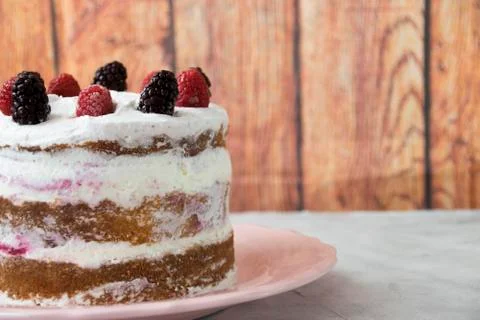 Side view of a sponge cake filled with whipped cream and berries sauce topped Stock Photos
