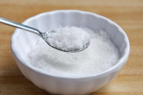 Side view of a spoon filled with coarse salt with customizable space for te.. Stock Photos