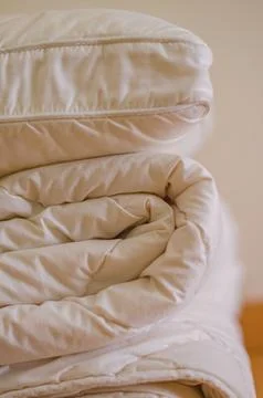 Side view of Stack of beddings , white pillow on the duvet Stock Photos