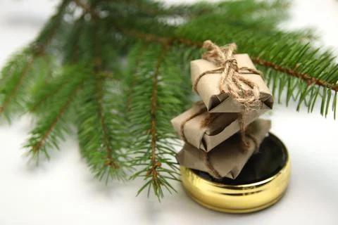 Side view stack of craft little gifts standing on round gold mirror on white  Stock-Fotos