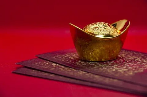 Side view of stack of red packets arranged neatly with golden ingot symboli.. Stock Photos