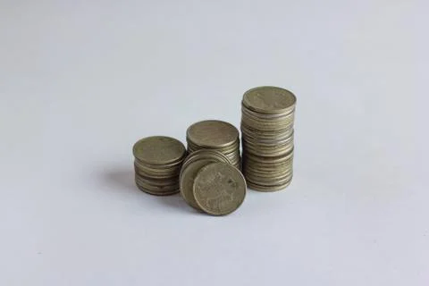 Side view of stacks of coins increasing in height, on white studio background Stock Photos