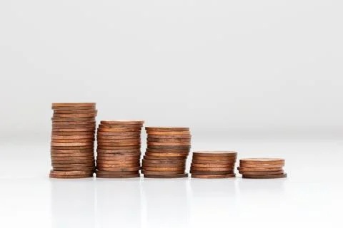 Side view of stacks of coins increasing in height, on white studio background Stock Photos
