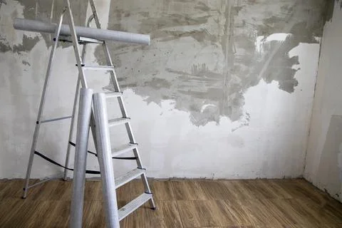 Side view of a stepladder and rolls of non-woven  Stock Photos