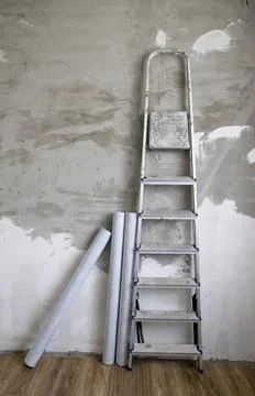 Side view of a stepladder and rolls of non-woven Stock Photos