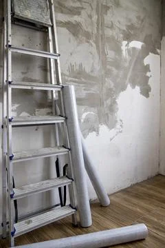 Side view of a stepladder and rolls of non-woven Stock Photos